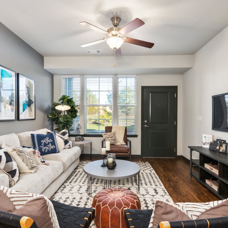Authentix apartment interior with couch, circular coffee table, window, and exterior door